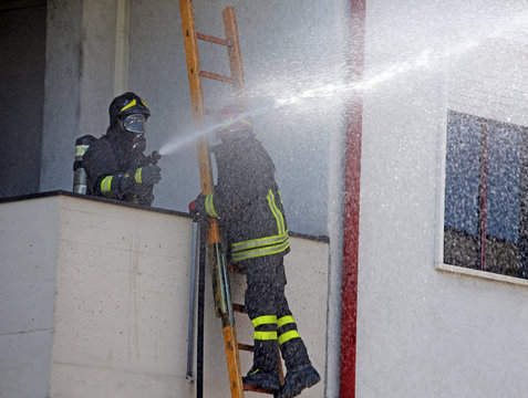 Firefighter sprays water with the spear fighting during the exer