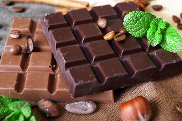 Chocolate with mint, spices and coffee beans on table, closeup