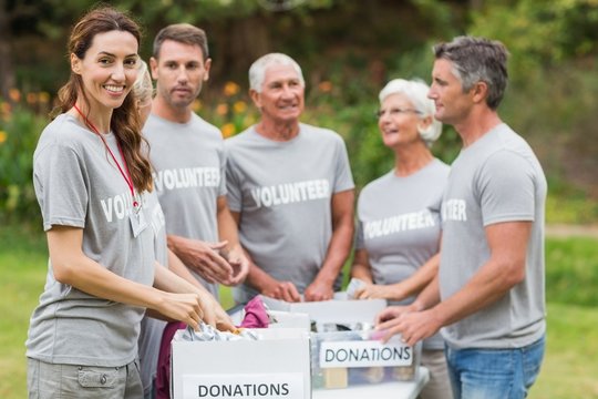 Happy volunteer family holding donation boxes 