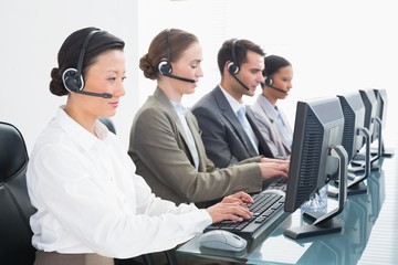 Business people with headsets using computers