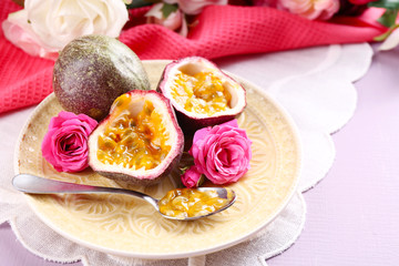 Passion fruit on plate on color wooden background
