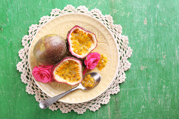 Passion fruit on plate on color wooden background
