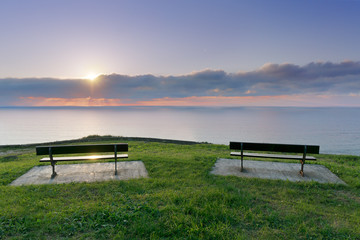 Naklejka na ściany i meble benches near sea at sunset