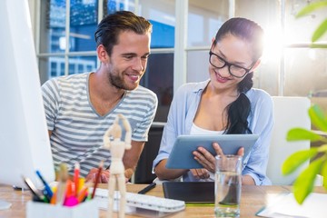 Fototapeta premium Smiling partners working together on tablet