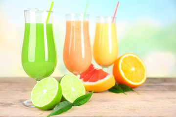 Fresh summer cocktails on wooden table on bright blurred background
