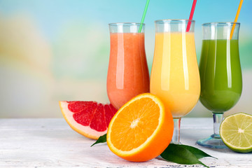 Fresh summer cocktails on wooden table on bright blurred background