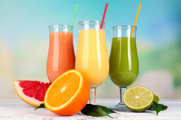 Fresh summer cocktails on wooden table on bright blurred background