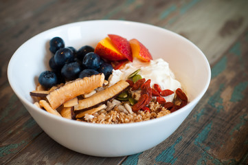 Breakfast muesli made with Greek yogurt and topped with fresh nectarines, blueberries, coconut and goji berries. Packed with vitamins this homemade muesli a healthy and nutritious start to the day.