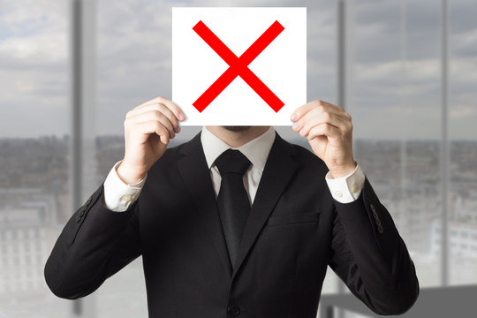businessman hiding face behind sign crossed out