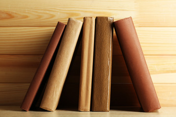 Books on shelf, close-up, on wooden background