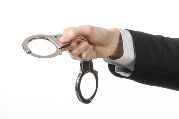 businessman in a black suit with handcuffs on his hands studio
