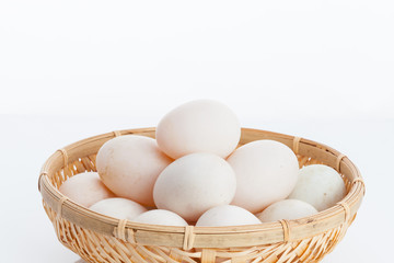 Raw dirty duck eggs in the bamboo bowl basket on white backgroun