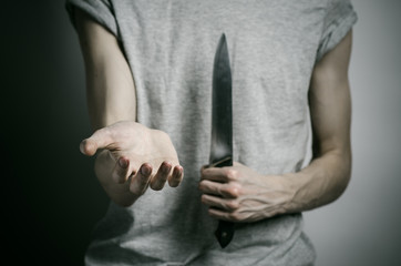 a man holding a knife on a gray background studio