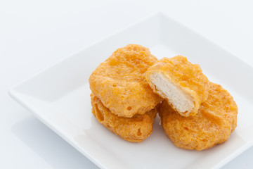 Group of fried chicken nuggets on white dish
