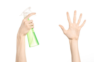 man's hand holding a green spray bottle for cleaning
