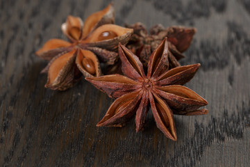 anise stars on old oak table close up photo