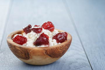 cottage cheese with preserved strawberry on blue table