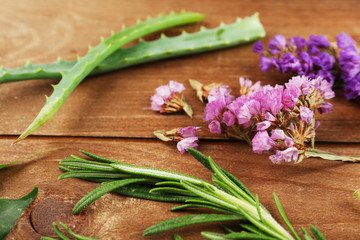 Fototapeta na wymiar Green herbs and leaves on wooden table, closeup