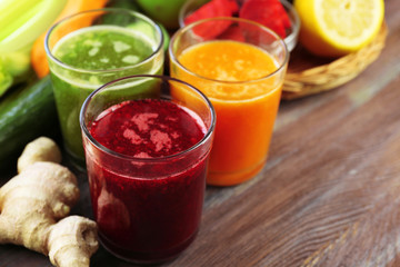 Fototapeta na wymiar Assortment of healthy fresh juices on wooden table background