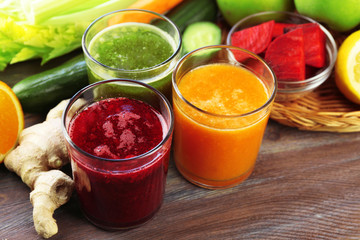 Assortment of healthy fresh juices on wooden table background