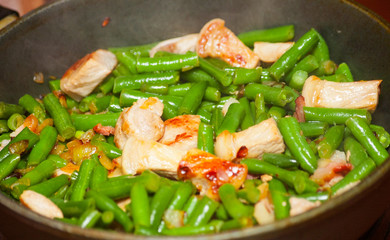 Cooking meat with green beans in fried pan