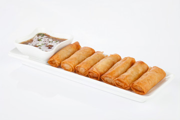 crispy spring rolls on white dish with Sweet & Sour Sauce.