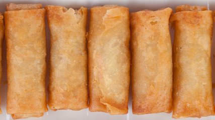 crispy spring rolls on white dish with Sweet & Sour Sauce.