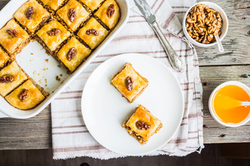 pieces of baklava with honey and nuts, top view, rustic