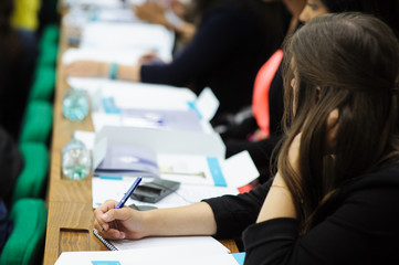 Student women sitting at the class writing a test or exams