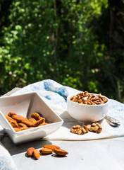 nuts, almonds and walnuts in a white plate on a light background