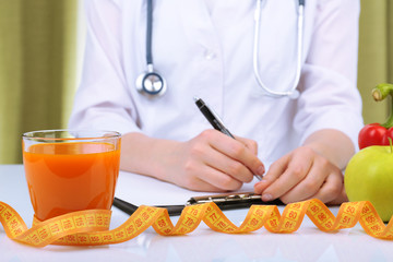Nutritionist doctor writing  diet plan in office