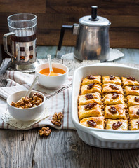 Turkish homemade baklava with honey and walnuts in a white bowl