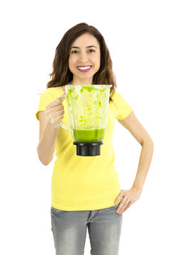 Woman showing green smoothie in a mixer jar