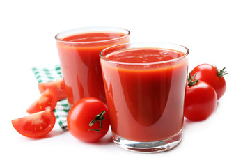Glasses of fresh tomato juice on checkered napkin, isolated on white