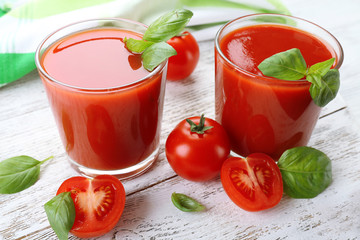 Glasses of fresh tomato juice on wooden table, closeup