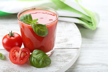 Glass of fresh tomato juice on wooden table, closeup