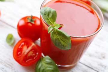 Glass of fresh tomato juice on wooden table, closeup