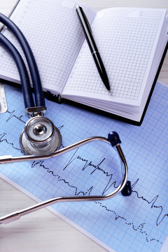 Cardiogram with stethoscope on table, closeup