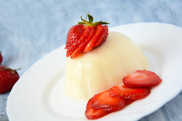 Panna cotta with strawberries on white plate