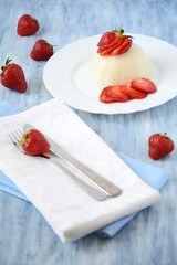 Panna cotta with strawberries on white plate
