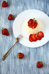 Panna cotta with strawberries on white plate