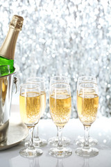 Glasses of champagne on bright background
