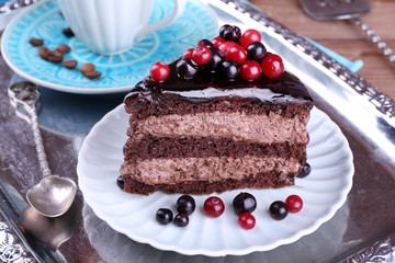 Delicious chocolate cake with berries on plate on table close up