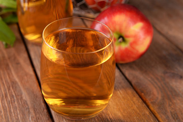 Glasses of apple juice on wooden table, closeup