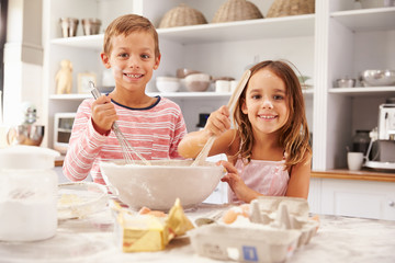 Two children having fun baking in the kitchen
