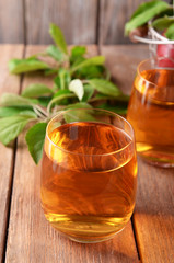 Glasses of apple juice on wooden background