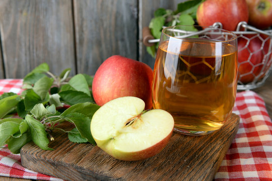 Glass of apple juice on wooden background