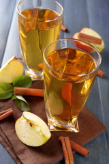 Glasses of apple juice on wooden table, closeup