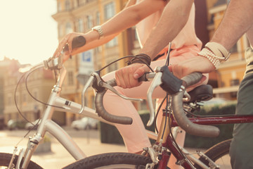 Closeup of couple hands on bikes