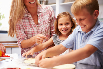 Obraz na płótnie Canvas Mother preparing pizza with kids